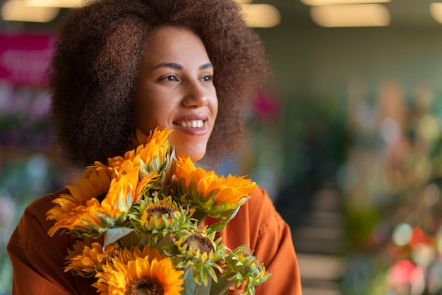 Kostenloses Foto mittlere schussfrau mit schönen sonnenblumen