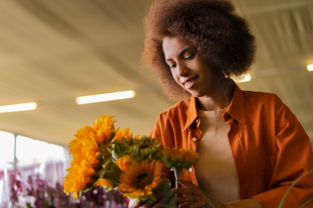 Kostenloses Foto mittlere schussfrau mit schönen sonnenblumen