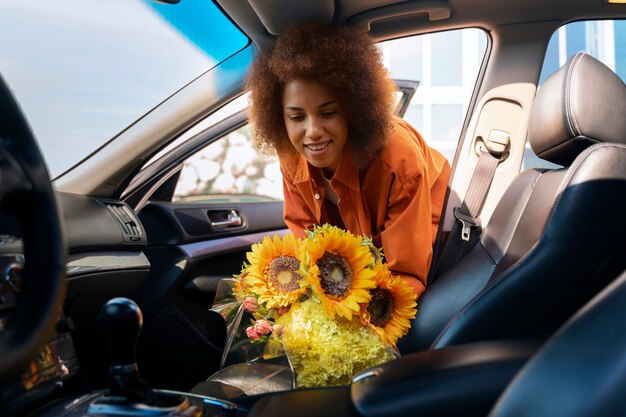 Kostenloses Foto mittlere schussfrau mit schönen sonnenblumen