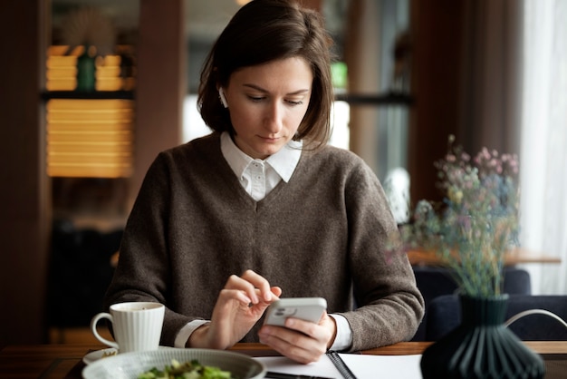 Mittlere Schussfrau mit Smartphone