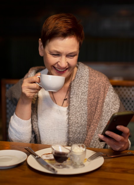 Mittlere Schussfrau mit Tasse und Telefon