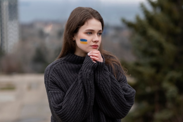 Kostenloses Foto mittlere schussfrau mit ukrainischer flaggenzeichnung