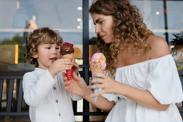 Mittlere schussfrau und -kind mit eiscreme