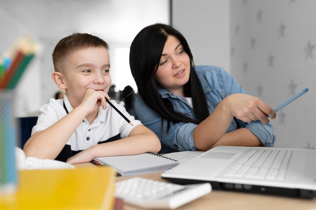 Mittlere Schussfrau und Kind mit Laptop