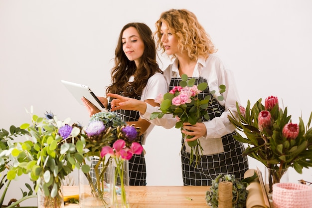 Mittlere Schussfrauen, die am Blumenladen arbeiten