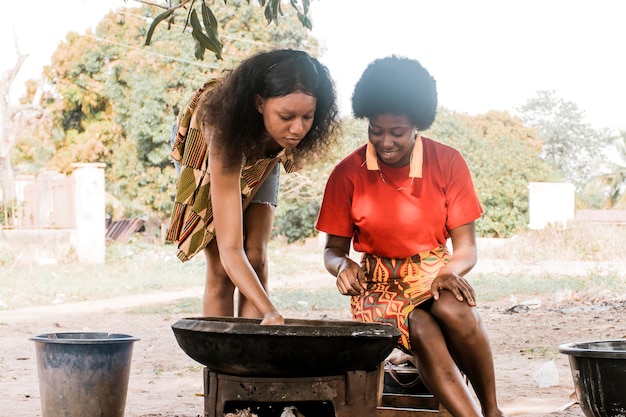 Kostenloses Foto mittlere schussfrauen, die draußen kochen