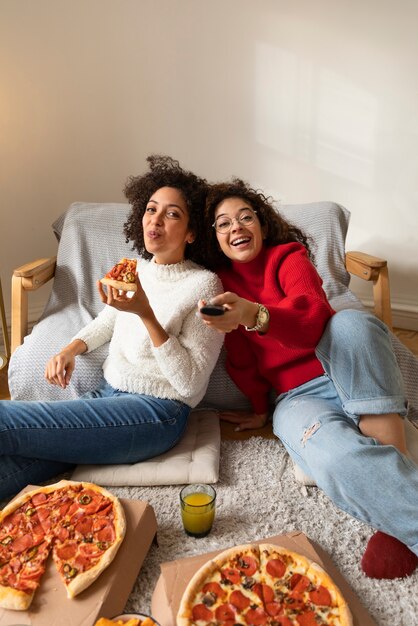 Mittlere Schussfrauen, die fernsehen