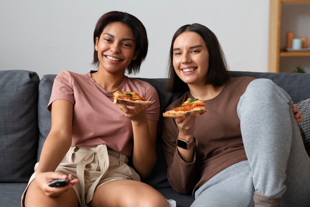 Kostenloses Foto mittlere schussfrauen, die köstliche pizza essen