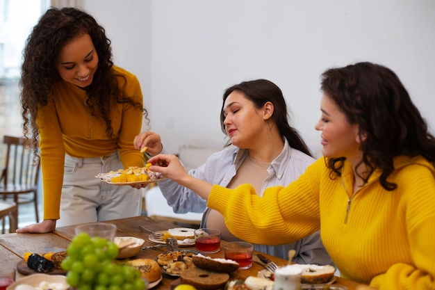 Kostenloses Foto mittlere schussfrauen, die köstliches essen genießen