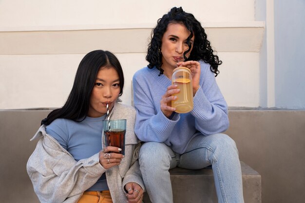 Mittlere Schussfrauen, die Kombucha trinken