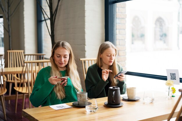 Mittlere schussfrauen, die qr-codes scannen