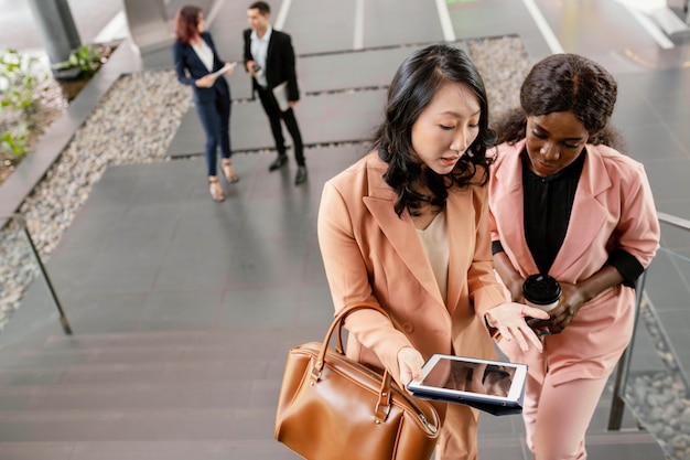 Mittlere Schussfrauen, die Tablette betrachten