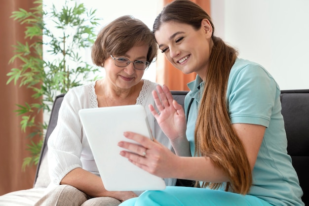 Mittlere Schussfrauen, die Tablette betrachten