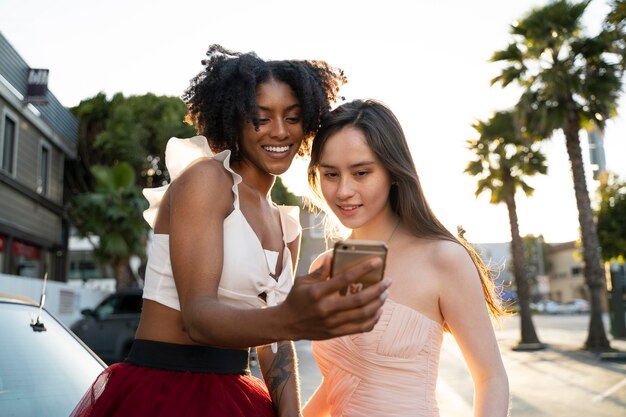 Mittlere Schussfrauen, die Telefon betrachten