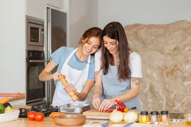 Mittlere Schussfrauen, die zusammen kochen