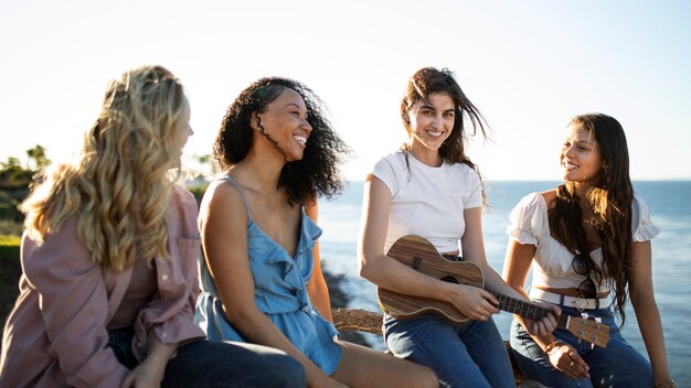 Mittlere schussfrauen mit gitarrenmusik draußen