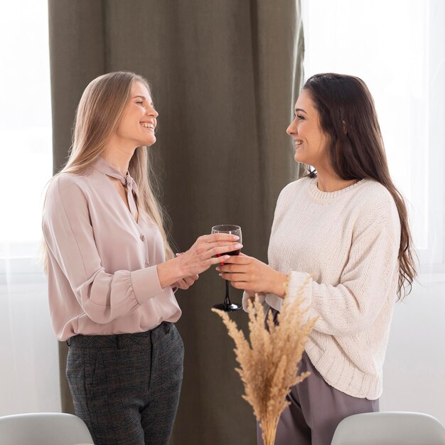 Mittlere Schussfrauen mit Glas Wein