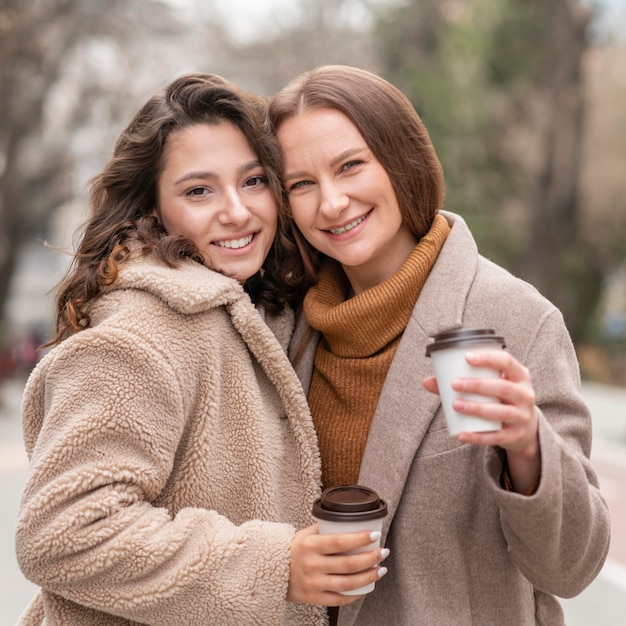 Mittlere Schussfrauen mit Kaffee im Freien