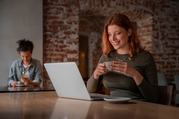 Kostenloses Foto mittlere schussfrauen mit laptop im café