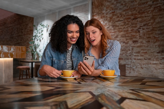 Kostenloses Foto mittlere schussfrauen mit smartphone