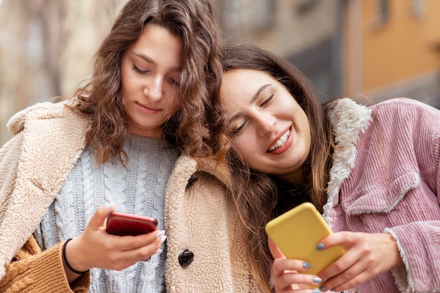 Mittlere Schussfrauen mit Smartphones