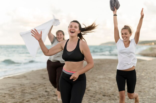 Mittlere Schussfreunde, die am Strand laufen