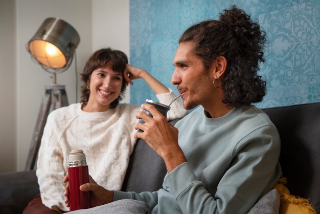 Mittlere Schussfreunde, die auf Couch sitzen