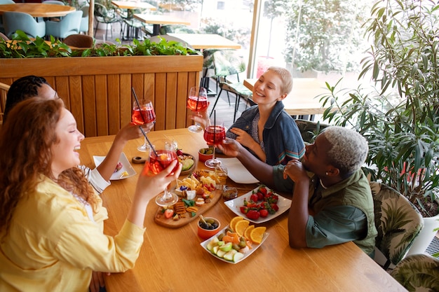 Kostenloses Foto mittlere schussfreunde, die cocktails trinken