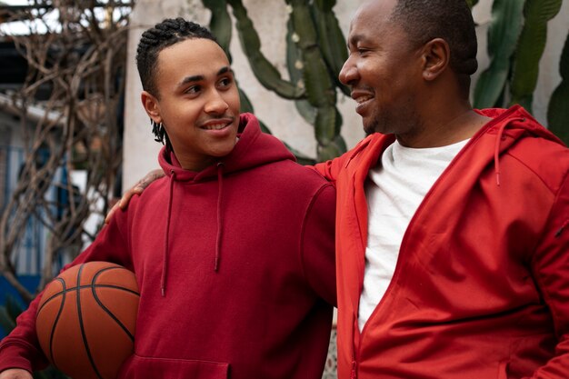 Mittlere Schussfreunde, die draußen Basketball spielen