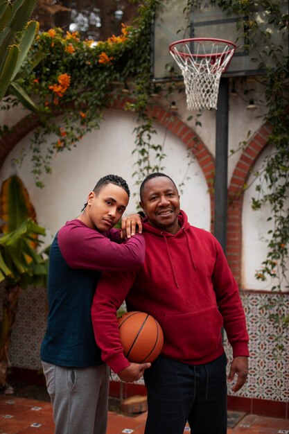 Mittlere Schussfreunde, die draußen Basketball spielen