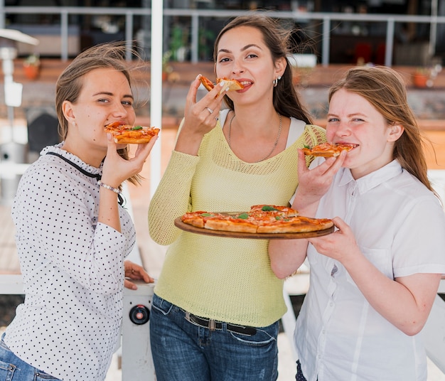 Kostenloses Foto mittlere schussfreunde, die pizza essen