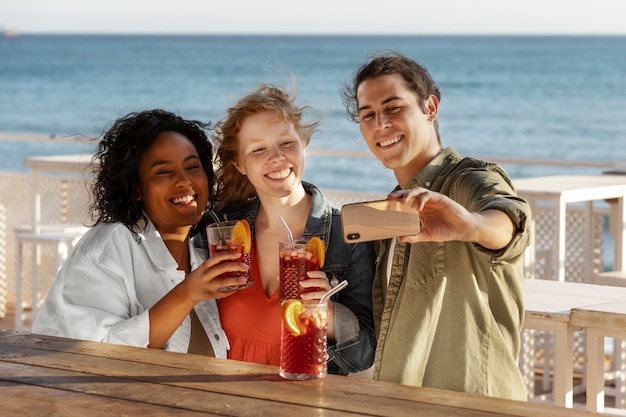 Kostenloses Foto mittlere schussfreunde, die selfie mit sangria nehmen