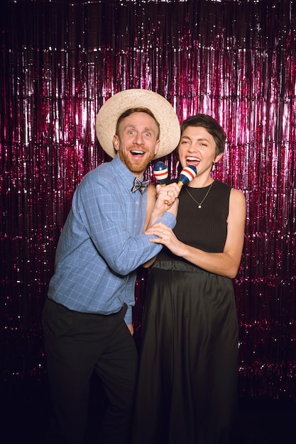 Mittlere Schussfreunde, die zusammen in der Photobooth posieren