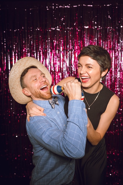 Mittlere Schussfreunde, die zusammen in der Photobooth posieren