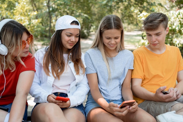 Mittlere Schussgruppe von Freunden, die Telefon betrachten