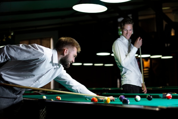 Kostenloses Foto mittlere schusskerle, die zusammen billard spielen