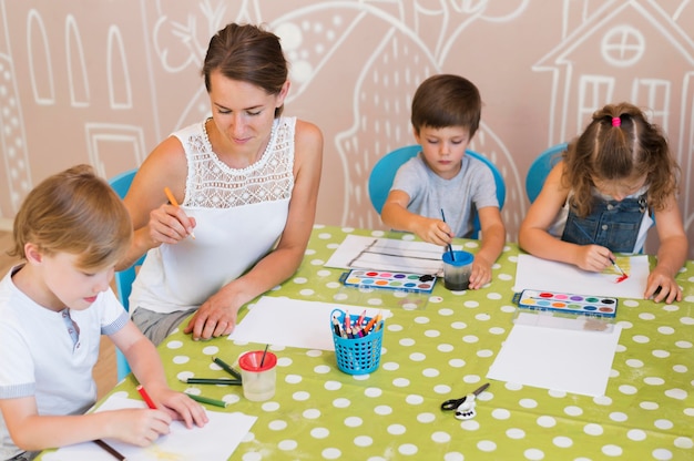 Mittlere Schusskinder, die am Tisch malen