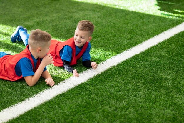 Mittlere Schusskinder, die auf Gras legen