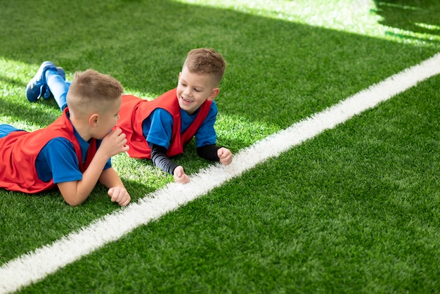 Mittlere Schusskinder, die auf Gras legen