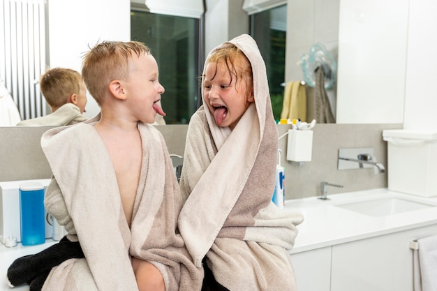 Mittlere Schusskinder, die im Badezimmer sitzen