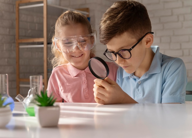 Kostenloses Foto mittlere schusskinder mit lupe