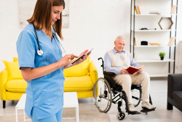 Mittlere Schusskrankenschwester, die ihre Tablette überprüft