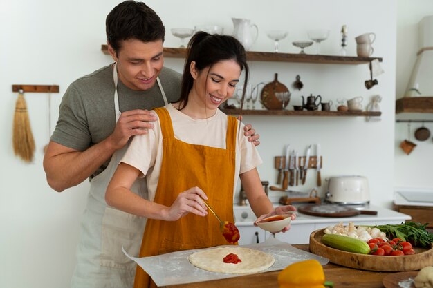 Mittlere schussleute, die zusammen pizza kochen