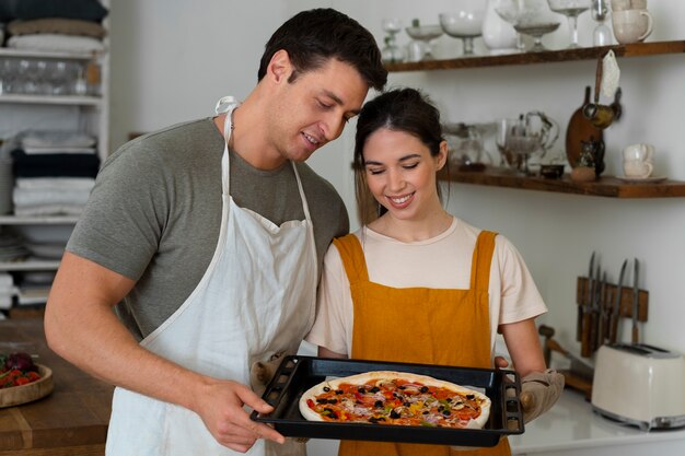 Mittlere schussleute, die zusammen pizza kochen