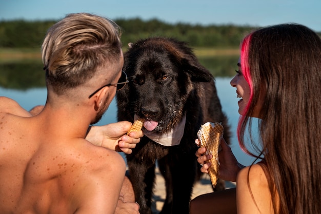 Mittlere schussleute mit nettem hund am strand