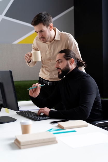 Kostenloses Foto mittlere schussmänner, die im büro zusammenarbeiten