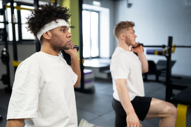 Kostenloses Foto mittlere schussmänner, die mit kettlebells trainieren