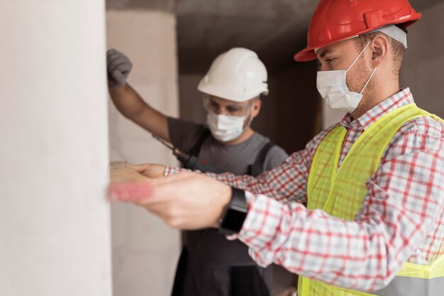 Mittlere Schussmänner, die mit Masken arbeiten