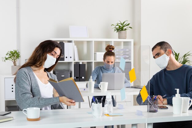 Mittlere Schussmitarbeiter, die Masken tragen