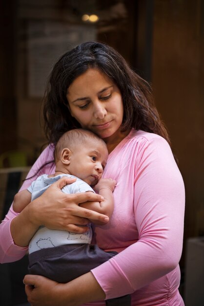 Mittlere Schussmutter, die Baby hält